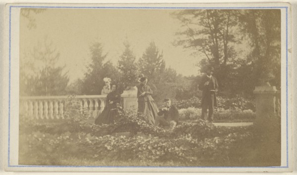Five  people: three women and one man standing, one man seated, in a garden; 1865 - 1870; Albumen silver print