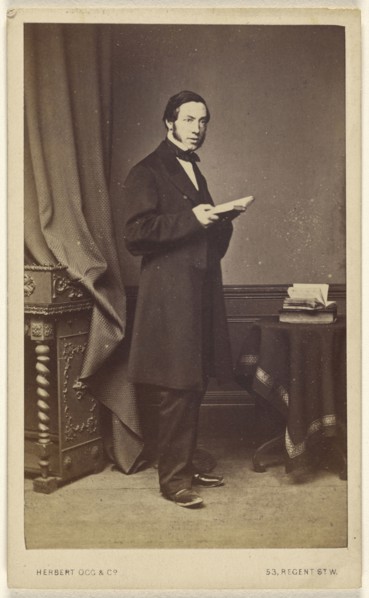 man with long sideburns standing with an open book; Herbert Ogg & Company; about 1865; Albumen silver print