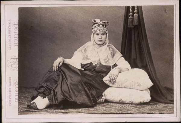 Algerian woman seated on floor with arm resting on cushions, Cities and sites cabinet card collection, Veuve Plasse et Oberty