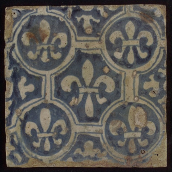 Two-tone tile, blue on white background, four circles with white French lily around central ornament with lily, wall tile