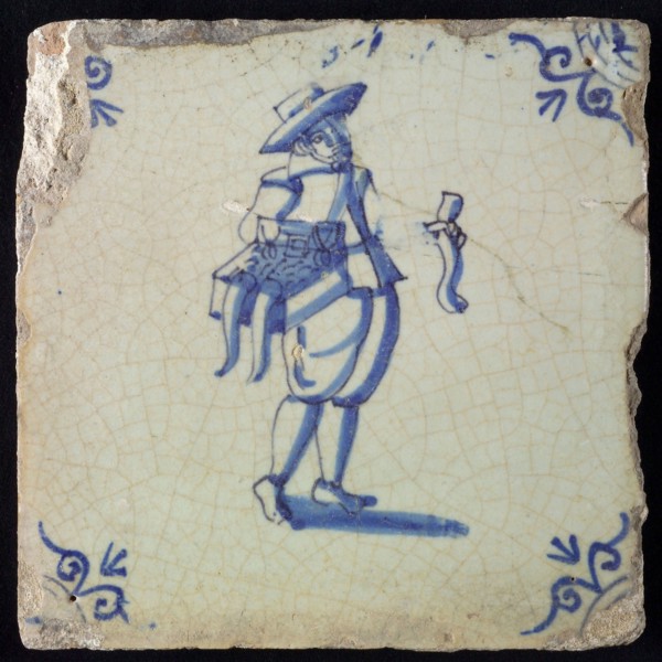 Occupation tile, blue with hawker with chest with merchandise on the hip, corner motif ox's head, wall tile tile sculpture