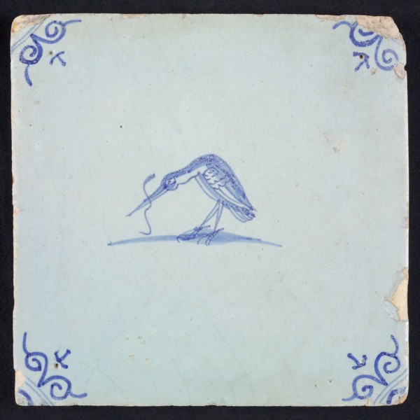 Animal tile, bird with long fish in its beak to the left, blue on white, corner motif ox's head, wall tile tile sculpture