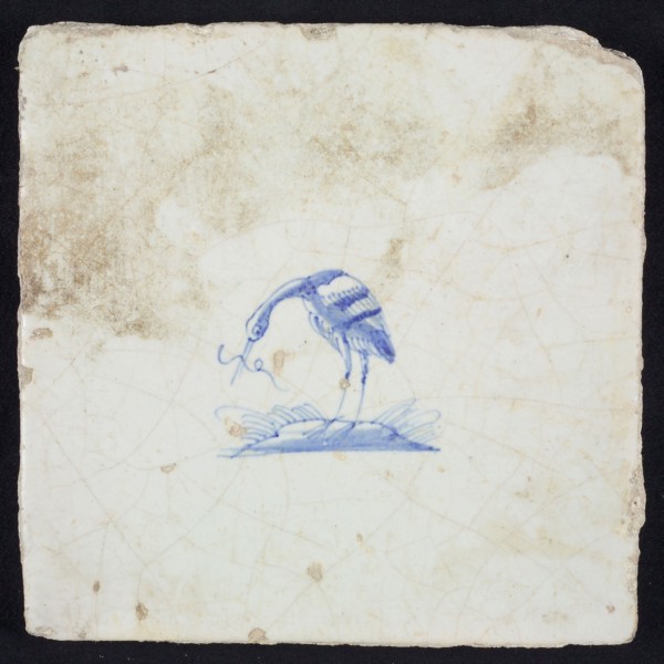 Animal tile, bird on plot with long fish in its beak to the left, blue on white, no corner pattern, wall tile tile sculpture