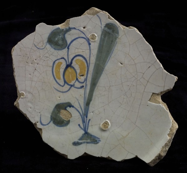 Fragment of the majolica dish, polychrome, tulip or snowdrop on the ground, plate crockery holder soil find ceramic earthenware