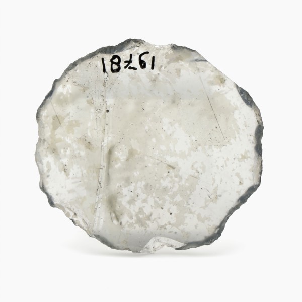 Oval glass disk of thin window glass, disc artifact soil find glass, cast cut cut Oval slice thin window glass