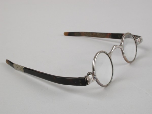 Glasses with round lenses on strength, silver-colored metal frame and short flat feathers of turtle, children's glasses