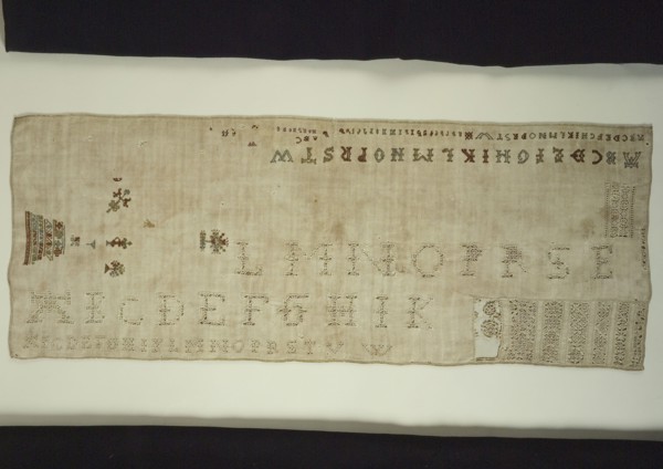 Sampler or lettercloth worked in colored silk and natural linen on cream colored linen in cross stitch and reticella