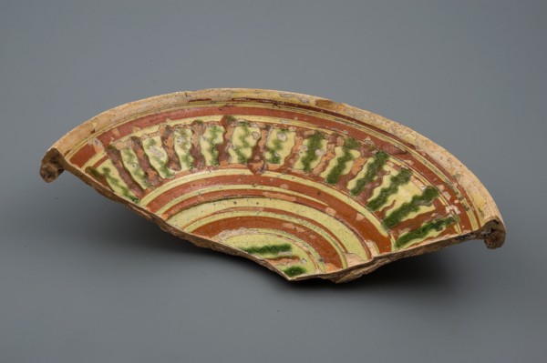 Fragment earthenware dish with green and brown silt decoration on yellow ground, plate dish crockery holder soil find ceramic