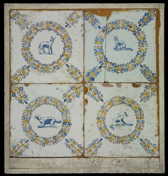 Tile field, four tiles, blue, yellow and brown on white, with goat In aigrettekrans and three times dog in aigrettekrans, corner