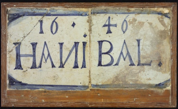 Two tiles next to each other in wooden frame, blue on white, outlined in blue: 1646 and HANIBAL, tile picture material ceramic