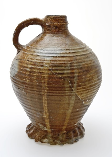 Large stoneware jug on heavy pinched foot, radstamp decoration around neck and shoulder, jug holder kitchen utensils earthenware