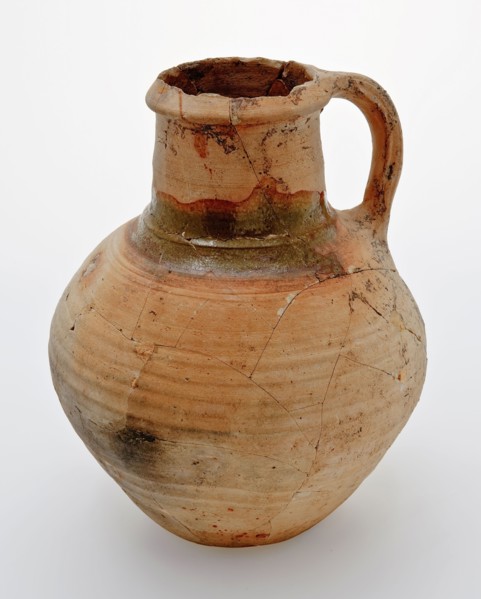 Pottery jug on lens bottom, yellowish shard, green lead glaze on the shoulder, jug crockery holder soil find ceramic earthenware