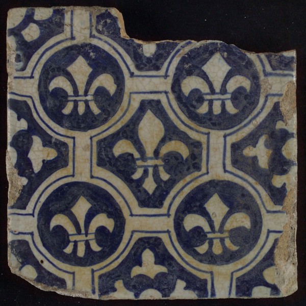 Two-tone tile, blue on white background, four circles with white French lily around central ornament with lily, wall tile