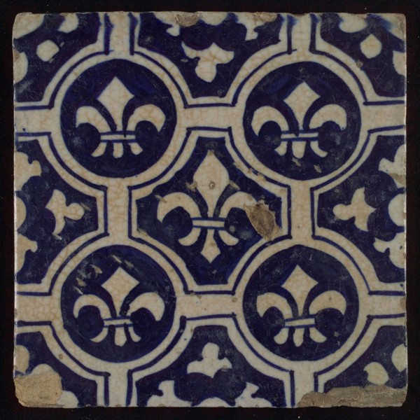 Two-tone tile, blue on white background, four circles with white French lily around central ornament with lily, wall tile