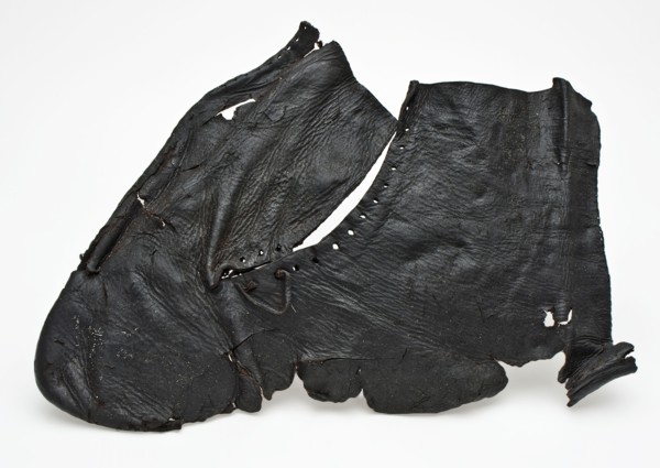One piece cut upper piece of shoe or half boot with round holes and part of leather lace, shoe footwear clothing soil finding