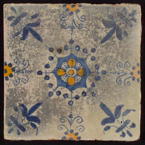 Tile, blue draft and orange on white, central flower within star shape, three-spot around, half rosette, corner pattern lily