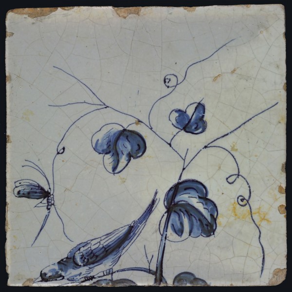 Blue tile with bird sitting on grape leaf tending downwards, dragonfly to tendril, of chimney pilaster with 13 tiles, tree