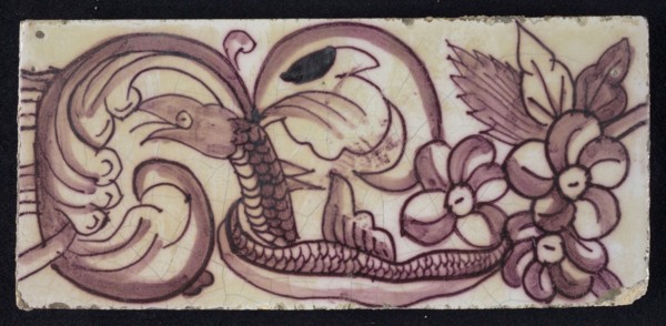 Rectangular edge tile in purple with hinged decor of leaves, flowers and twisted snake with scales and fin, border tile wall