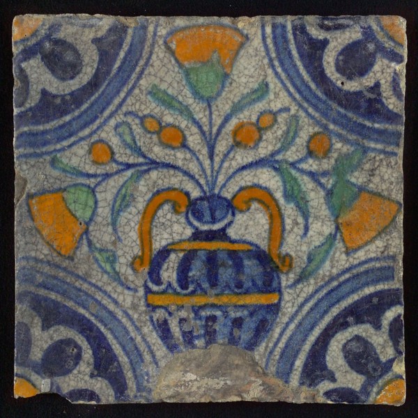 Tile, blue pull, orange, yellow and green on white, central flowerpot with marigolds, corner pattern, rosette, wall tile