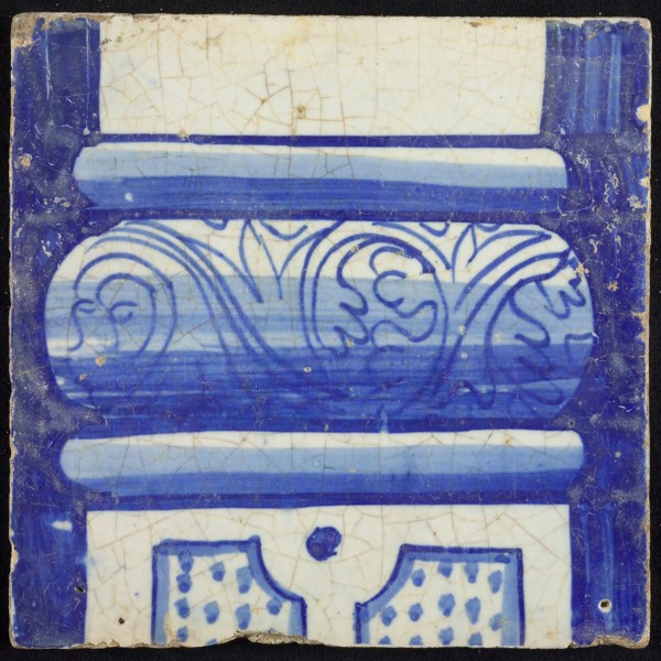 Tile of chimney pilaster, blue on white, bottom of column with basement with curly floral decoration, division with dots