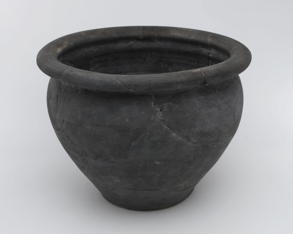 Black storage jar on standing surface, folded upper edge above constriction, storage jar pot holder soil find ceramic