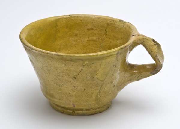 Yellow head with ear, tapered form, constriction above the foot, cup crockery holder soil find ceramic earthenware glaze lead