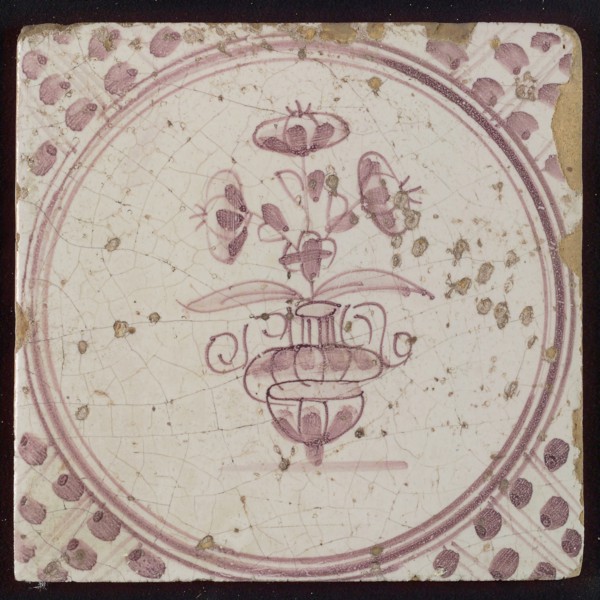 White tile with purple small flowerpot in circle frame with meanders, wall tile tile sculpture ceramic earthenware glaze, baked