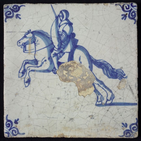 White tile with blue horseman with armor, shield and sword; corner pattern ox head, wall tile tile sculpture ceramic earthenware