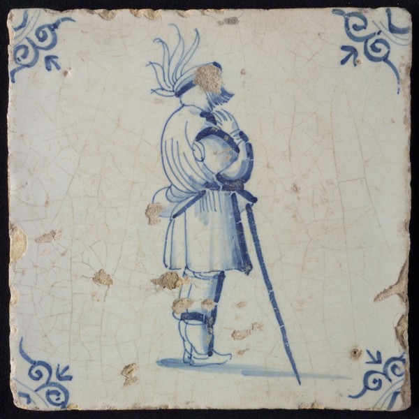 White tile with blue warrior leaning on stick; corner pattern ox head, wall tile tile sculpture ceramic earthenware glaze, baked
