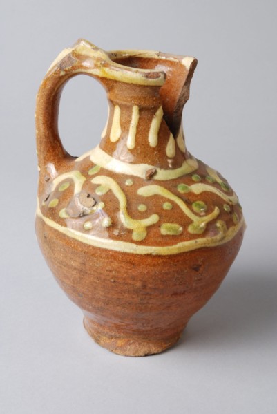 Earthenware oil jug on stand with standing ear and silt decoration on neck and shoulder, oil jug crockery holder soil find