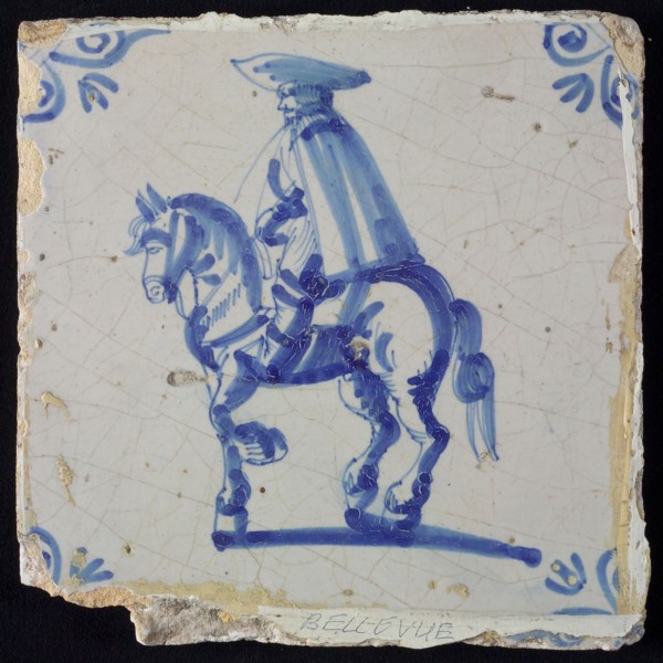 White tile with blue rider with cape and hat; corner pattern ox head, wall tile tile sculpture ceramic earthenware glaze, baked