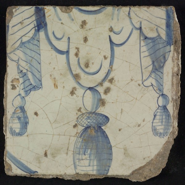 Tile of chimney pilaster, blue on white, bottom of pleated lap with three hanging tassels, chimney pilaster tile pilaster