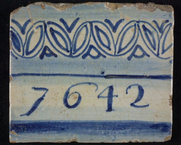 Tile of chimney pilaster, blue on white, between two blue shaded edges 1642, above edge with ornaments, chimney pilaster tile