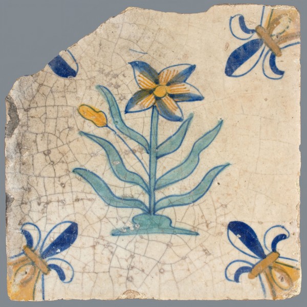 Tile, flower on ground in yellow, brown, green and blue on white, corner pattern french lily, corner point yellow, wall tile