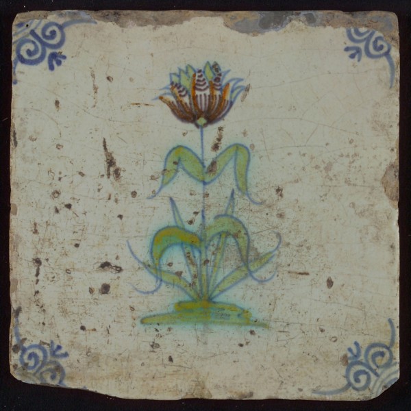 Tile, flower on ground in orange, brown, green and blue on white, corner motif oxen head, wall tile tile sculpture ceramic