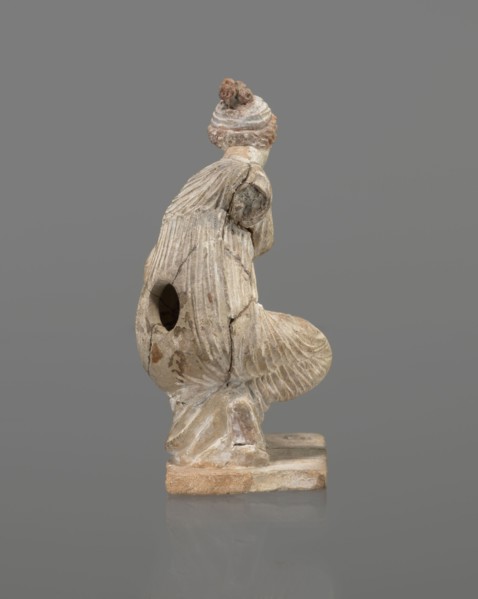 Terracotta figurine of a girl throwing dice. Figurine of a crouching girl throwing dice: weight of