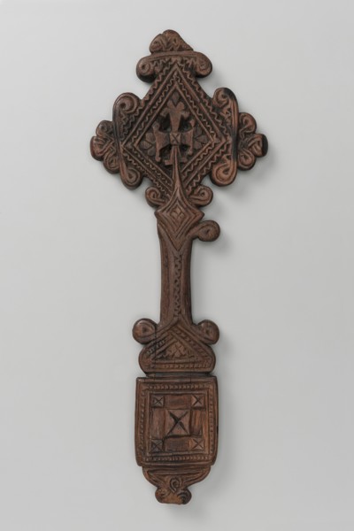 Hand cross. The arms of the cross are rhombus-shaped, the tops decorated with volutes topped with