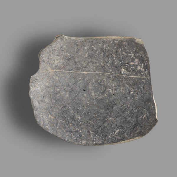 Fragment of a bucchero nero bowl with a flat bowl and a ring-shaped stem. On the inside of the bowl