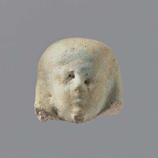 Fragment of a shabti. Fragmentary head of a shabti figurine with indistinct facial features, in a