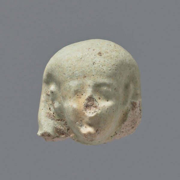 Fragment of a shabti. Head of a shabti figurine with not very carefully rendered facial features,
