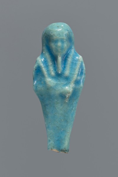 Shabti, mummy-shaped figurine, funerary gift. Back supported by a pillar/pilaster. Legs missing up