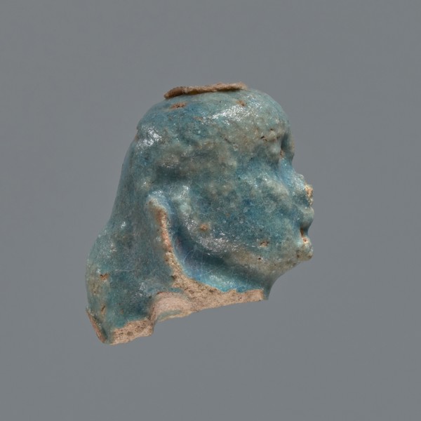 Shabti head, Mummy-shaped figurine head depicting a king. Oval face with full cheeks, prominent