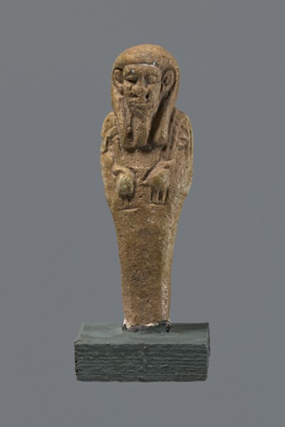 Shabti, mummy-shaped figurine standing on a base, back supported by a pillar/pilaster. Arms crossed