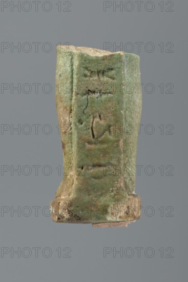 Shabti legs, mummy-shaped figurine fragment knees down. Feet rest on a base with a flat pillar at
