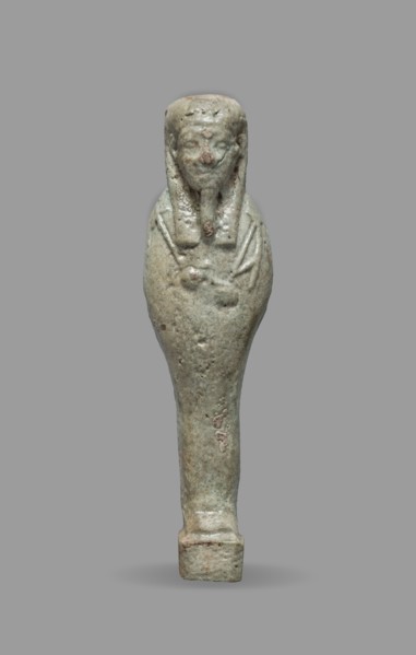 Ushabti, Mummy-shaped funerary figurine standing on a base, back supported by a flat pillar. Arms