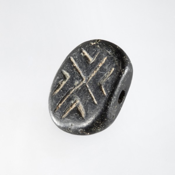 Stamp seal with geometric ornament. A prism-shaped stamp seal with rounded edges and an oval,