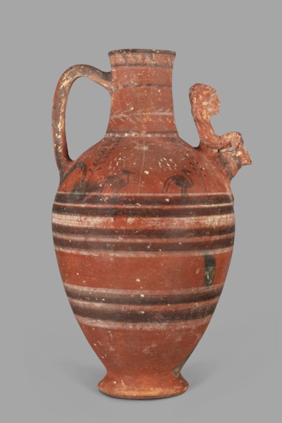Jug with a figurine of a woman with a jug. Cypriot pottery, female figurines applique. Jug on a