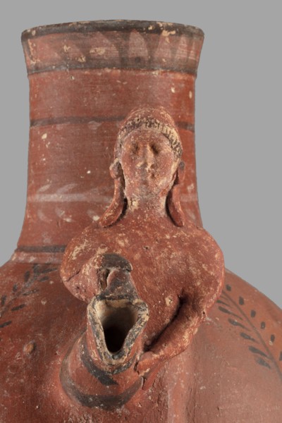 Jug with a figurine of a woman with a jug. Cypriot pottery, female figurines applique. Jug on a