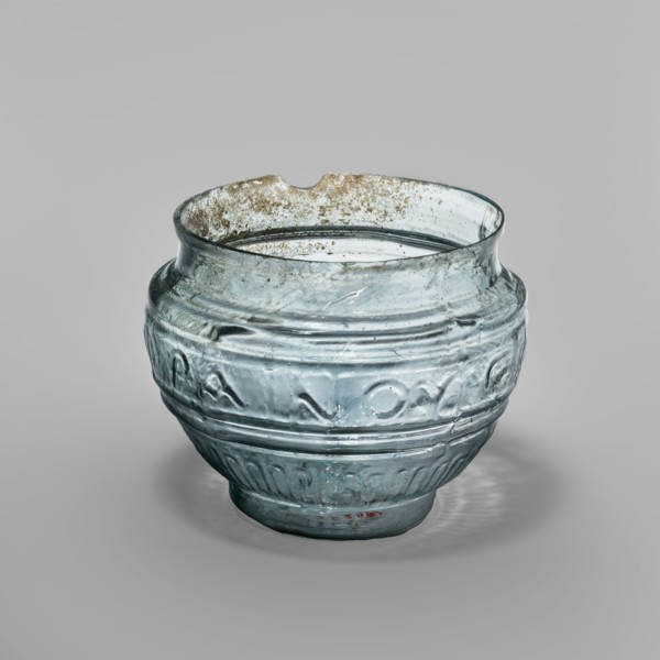 Glass bowl with Greek inscription. Transparent light-blue glass, uneven rim edge, cold-worked.