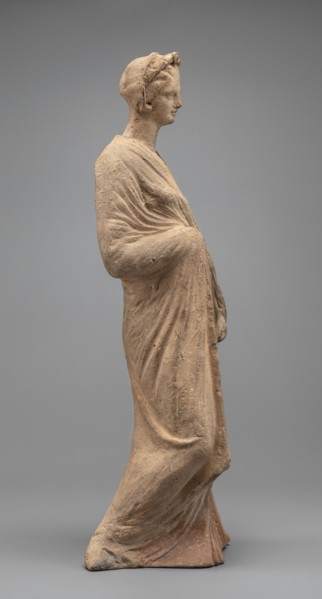Female figurine, standing woman dressed in a long robe, slightly pleated and belted high under the